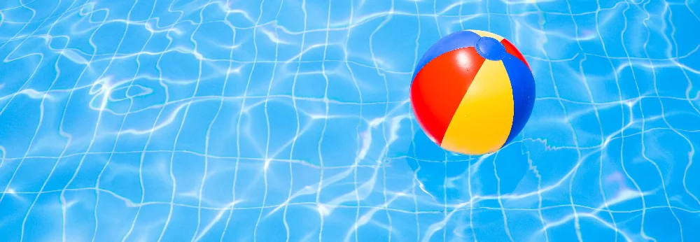 Strandball im blauen Pool